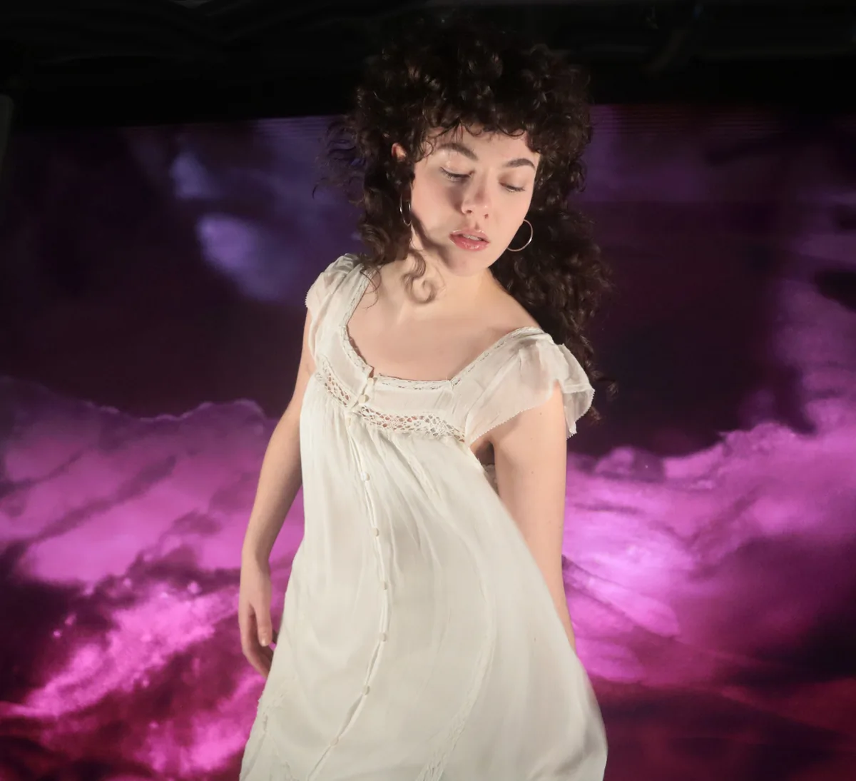 A student performer keyed off the green screen and composited against a rolling violet sky