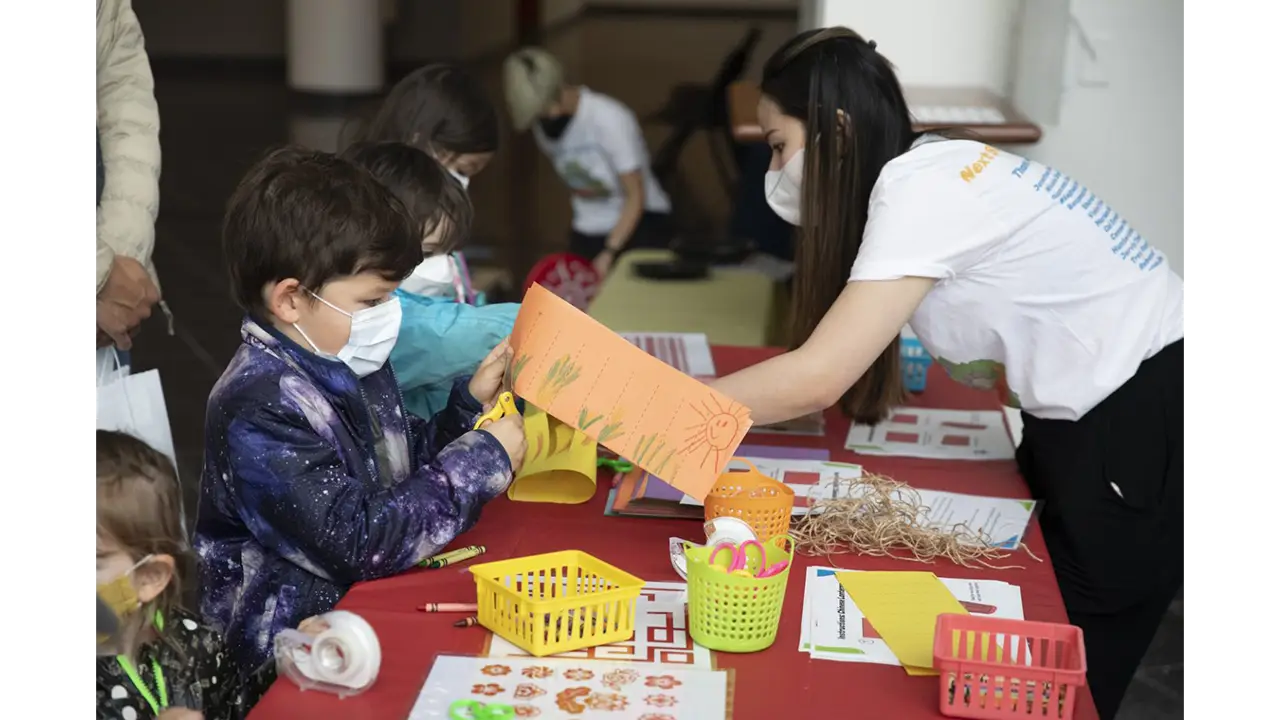 Children creating lanterns at Chinatown booth.